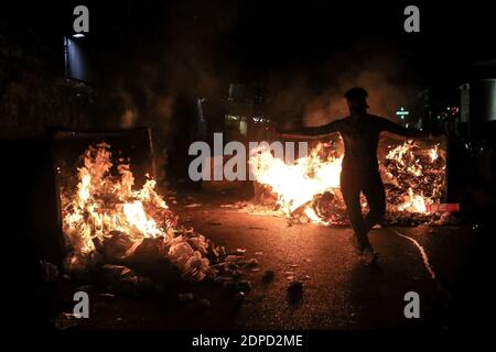 Beyrouth, Liban. 19 décembre 2020. Un militant anti-gouvernemental utilise un panneau de signalisation pour briser la fenêtre d'une banque locale lors d'une manifestation en raison de l'augmentation des frais de scolarité dans un contexte de crise économique aiguë et d'impasse politique qui engloutit le pays. Credit: Marwan Naamani/dpa/Alamy Live News Banque D'Images