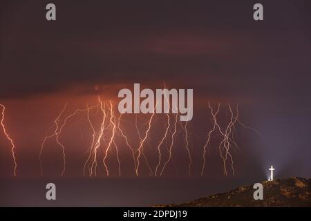 Paysage incroyable d'une magnifique fermeture éclair dans Dark Night Sky. Croix illuminée en haut de la montagne. Nature du Liban. Banque D'Images