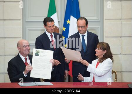 Le président français François Hollande (retour, R) avec son homologue mexicain Enrique Pena Nieto (retour, L) au poste de ministre français de l'écologie, Développement durable et énergie Ségolène Royal (R) et son homologue mexicain Juan Jose Guerra Abud signent une déclaration conjointe sur le climat lors d'une cérémonie de signature d'accords à l'Elysée Palace de Paris, France, le 16 juillet 2015. Plus de 60 accords, lettres d'intention, déclarations communes et mémorandums d'accord ont été signés entre le Mexique et la France lors de la visite d'État de quatre jours du Président Pena Nieto en France. Photo de Laurent Chamussy/Pool/ABA Banque D'Images