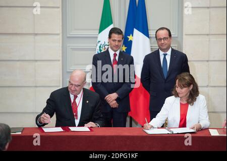 Le président français François Hollande (retour, R) avec son homologue mexicain Enrique Pena Nieto (retour, L) au poste de ministre français de l'écologie, Développement durable et énergie Ségolène Royal (R) et son homologue mexicain Juan Jose Guerra Abud signent une déclaration conjointe sur le climat lors d'une cérémonie de signature d'accords à l'Elysée Palace de Paris, France, le 16 juillet 2015. Plus de 60 accords, lettres d'intention, déclarations communes et mémorandums d'accord ont été signés entre le Mexique et la France lors de la visite d'État de quatre jours du Président Pena Nieto en France. Photo de Laurent Chamussy/Pool/ABA Banque D'Images