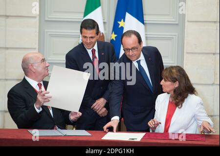 Le président français François Hollande (retour, R) avec son homologue mexicain Enrique Pena Nieto (retour, L) au poste de ministre français de l'écologie, Développement durable et énergie Ségolène Royal (R) et son homologue mexicain Juan Jose Guerra Abud signent une déclaration conjointe sur le climat lors d'une cérémonie de signature d'accords à l'Elysée Palace de Paris, France, le 16 juillet 2015. Plus de 60 accords, lettres d'intention, déclarations communes et mémorandums d'accord ont été signés entre le Mexique et la France lors de la visite d'État de quatre jours du Président Pena Nieto en France. Photo de Laurent Chamussy/Pool/ABA Banque D'Images