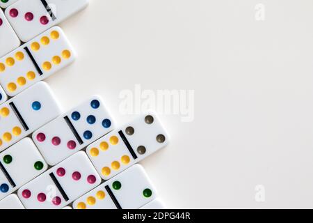 Dominos colorés disposés sur fond blanc avec un espace négatif pour copier Banque D'Images