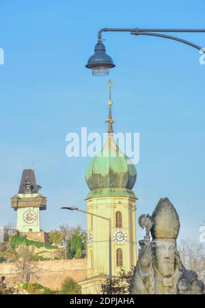 Ancienne statue de Saint-Nicolas, avec la tour de l'église franciscaine et la célèbre Tour de l'horloge en arrière-plan à Graz, en Styrie, en Autriche. Sélectif f Banque D'Images