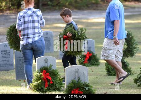 Bushnell, États-Unis. 19 décembre 2020. La famille DeGeorge de Tampa, en Floride, porte des couronnes à placer aux pierres angulaires des anciens combattants militaires américains au cimetière national de Floride.aujourd'hui, les bénévoles ont déposé 1.7 millions de couronnes dans 2,557 endroits participants aux États-Unis pour se souvenir et honorer les anciens combattants américains morts. Crédit : SOPA Images Limited/Alamy Live News Banque D'Images