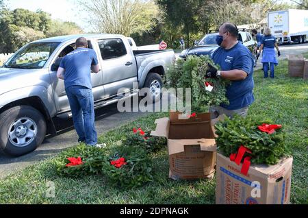 Bushnell, États-Unis. 19 décembre 2020. Des bénévoles distribuent des couronnes pour que les gens les placent sur les pierres angulaires des anciens combattants américains au cimetière national de la Floride.aujourd'hui, les couronnes nationales à travers la journée de l'Amérique, les bénévoles ont placé 1.7 millions de couronnes dans 2,557 endroits participants aux États-Unis pour se souvenir et honorer les anciens combattants américains morts. Crédit : SOPA Images Limited/Alamy Live News Banque D'Images