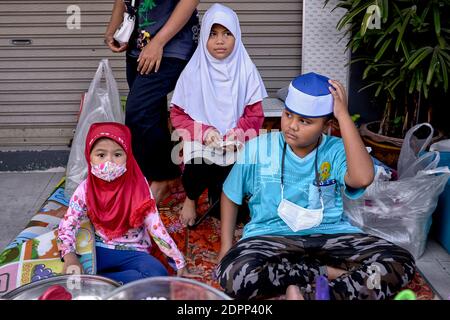 Enfants musulmans portant le hijab traditionnel pour les filles et les kufis ou chapeau taqiyah pour le garçon Banque D'Images