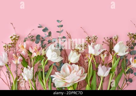 Branches alstroemeria de tulipes blanches et feuille verte sur fond rose pastel avec espace de copie. Joli papier peint pour la Saint-Valentin ou le mariage Banque D'Images