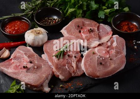 Sur une table, faire cuire de la viande fraîche d'ossobuco avec des épices et des herbes. Ingrédients pour ragoût italien Banque D'Images