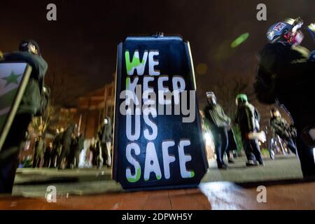 Washington, DC, Etats-Unis, 19 décembre 2020. Photo : des manifestants avec boucliers forment la ligne de front lorsqu'ils affrontent la police à la suite de la mort de Karon Hylton. Le message « nous gardons en sécurité » fait référence à la nécessité pour la communauté de garder tout le monde en sécurité parce que la police ne le fait pas. Les policiers du Metropolitan (DC) ont fait marche arrière sur son scooter après une poursuite, le blessant fatalement. Les poursuites contre la police pour violations de la circulation sont strictement interdites à Washington. Plusieurs plaintes ont déjà été déposées contre l'agent qui l'a frappé, Terrence Sutton. Crédit : Allison C Bailey/Alay Live News Banque D'Images