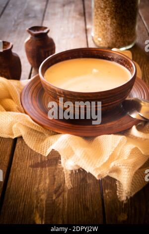 soupe de sarrasin au lait dans un bol en céramique sur table rustique, image verticale Banque D'Images