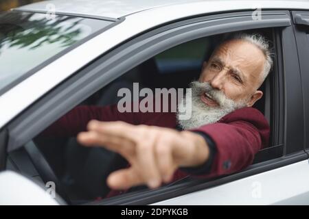 Homme nerveux conducteur combattant sur la route, coincé dans la circulation Banque D'Images