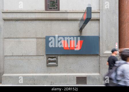 Un symbole Westpac Bank à la hauteur du sentier avec des personnes floues qui passent devant une succursale de la banque de la ville de Sydney en Australie Banque D'Images