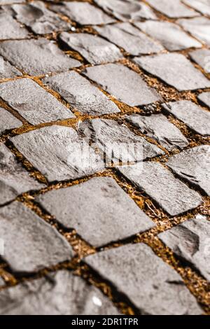 Chaussée en pierre en perspective. Résumé arrière-plan de la route pavée Old Cobblestone avec mousse verte Banque D'Images