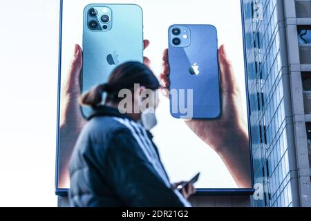 Séoul, Corée du Sud. 20 décembre 2020. Une femme portant un masque de protection passe devant une publicité iPhone 12 à Séoul. Crédit : SOPA Images Limited/Alamy Live News Banque D'Images