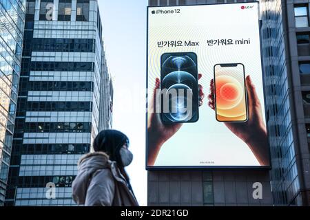 Séoul, Corée du Sud. 20 décembre 2020. Une femme portant un masque de protection passe devant une publicité iPhone 12 à Séoul. Crédit : SOPA Images Limited/Alamy Live News Banque D'Images