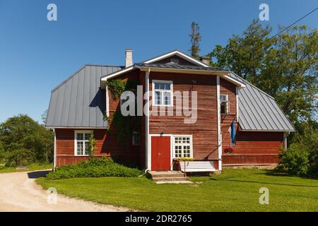 Cottage classique en bois rouge de style scandinave. Jour d'été ensoleillé. Drapeau estonien. Banque D'Images