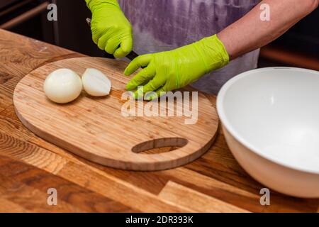 Vue en gros plan des mains de femmes épluchant les oignons. Concept de cuisine. Banque D'Images