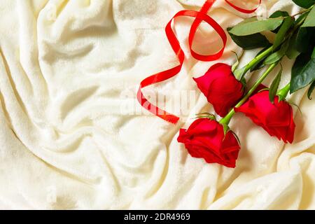 Cadeau romantique roses rouges sur le lit. Plan d'étapage avec vue de dessus. Copier l'espace. Banque D'Images