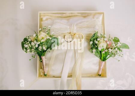 Anneaux d'engagement de mariage dans une boîte spéciale attachée de couleur crémeuse rubans Banque D'Images