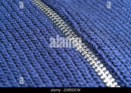 Photo macro de la fermeture éclair sur fond bleu laine avec coutures. Arrière-plan horizontal à partir d'un gros plan de laine Banque D'Images