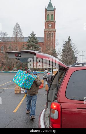 Detroit, Michigan, États-Unis. 19 décembre 2020. À l'église catholique St. Hedwig, le Michigan Muslim Community Council, en partenariat avec St. Hedwig's, a livré des boîtes de nourriture et des paquets de Noël aux familles dans le besoin. Les volontaires ont placé des boîtes dans des voitures lorsqu'ils ont traversé le parking de l'église. Les boîtes à nourriture provenaient du département de l'Agriculture des États-Unis. Crédit : Jim West/Alay Live News Banque D'Images