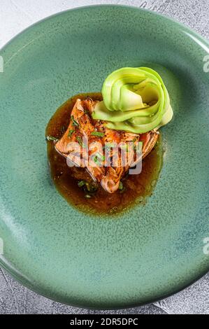 filet de saumon tatatataki avec garniture d'avocat. Arrière-plan gris. Vue de dessus. Banque D'Images