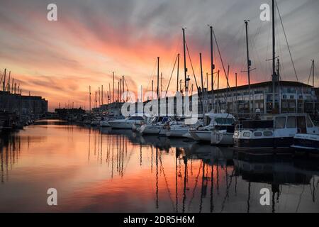 Port de plaisance pittoresque au coucher du soleil avec un ciel vibrant et des reflets sur l'eau calme, Brighton, Sussex, Angleterre, Royaume-Uni Banque D'Images