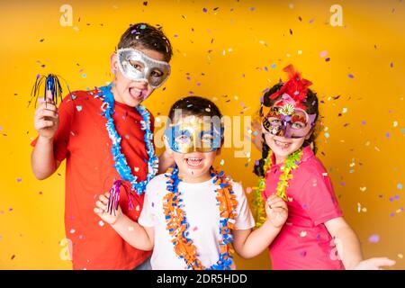 Trois enfants célèbrent le carnaval ou la Saint-Sylvestre chez eux Banque D'Images