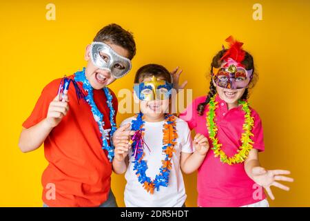 Trois enfants célèbrent le carnaval ou la Saint-Sylvestre chez eux Banque D'Images