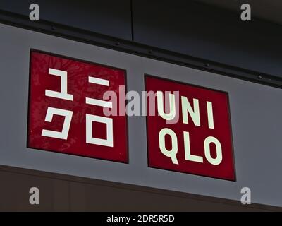 Logo de la société de couleur rouge de la chaîne japonaise UNIQLO (habillement) au-dessus de l'entrée du magasin de leur succursale dans la rue commerçante Königstraße. Banque D'Images