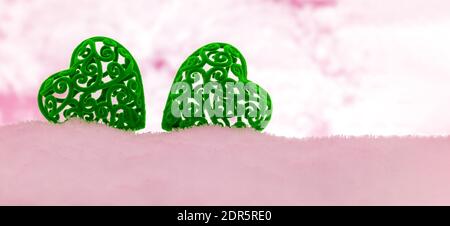 bannière avec deux coeurs en velours vert dans une chasse-neige rose avec un espace de copie Banque D'Images