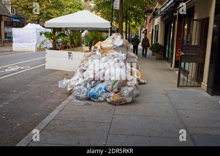 New York, NY, États-Unis - 20 décembre 2020 : les déchets sont emballés dans du plastique sur le trottoir et sont prêts à être ramassés Banque D'Images