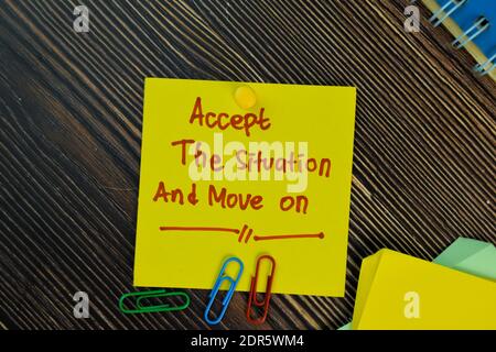 Acceptez la situation et passez à l'écriture sur les notes adhésives isolées sur la table en bois. Concept de motivation Banque D'Images