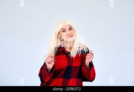 fille dans une chemise pose sur un fond blanc Banque D'Images