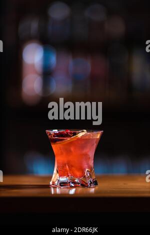 Cocktail de canneberges Deliciouse avec glaçons. Un barman expérimenté prépare un cocktail de canneberges au bar. Boisson alcoolisée rouge. Banque D'Images