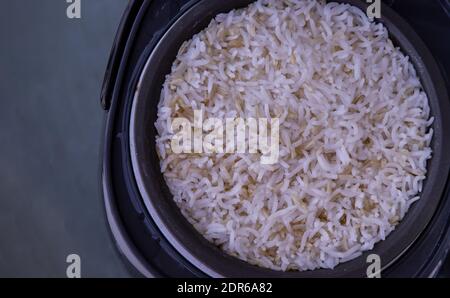 Riz au jasmin cuisson mélangée avec du riz brun grossier (riz blanchi imparfaitement nettoyé, non poli ou à moitié moulu) dans un cuiseur à riz électrique à vapeur Banque D'Images