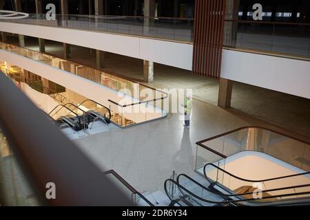 Vue en grand angle chez une femme mécanicien tenant des plans tout en se tenant dans un centre commercial ou un immeuble de bureaux en construction, espace de copie Banque D'Images