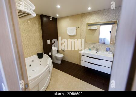 L'intérieur de la chambre d'hôtel est de couleurs brunes. Salle de bains avec grand jacuzzi Banque D'Images