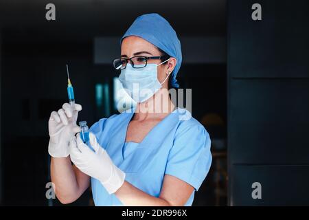 Femme latine médecin tenant une injection de vaccin pour le coronavirus covid 19 La vaccination mondiale en Amérique latine Banque D'Images