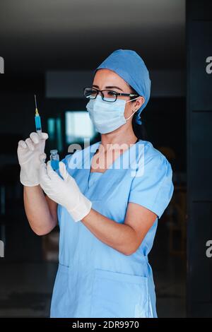 Femme latine médecin tenant une injection de vaccin pour le coronavirus covid 19 La vaccination mondiale en Amérique latine Banque D'Images