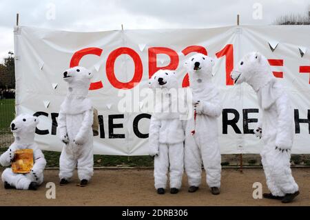 Les personnes portant des costumes d'ours polaires sont vues tandis que les activistes présentent une manifestation près de la Tour Eiffel à Paris, en France, le 12 décembre 2015. Un projet d'accord de 195 pays visant à réduire les émissions de gaz piégés par la chaleur qui menacent de faire des ravages sur le système climatique de la Terre doit être présenté à la Conférence des Nations Unies sur les changements climatiques COP21 à le Bourget, à la périphérie de Paris. Photo d'Alain Apaydin/ABACAPRESS.COM Banque D'Images