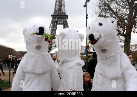 Les personnes portant des costumes d'ours polaires sont vues tandis que les activistes présentent une manifestation près de la Tour Eiffel à Paris, en France, le 12 décembre 2015. Un projet d'accord de 195 pays visant à réduire les émissions de gaz piégés par la chaleur qui menacent de faire des ravages sur le système climatique de la Terre doit être présenté à la Conférence des Nations Unies sur les changements climatiques COP21 à le Bourget, à la périphérie de Paris. Photo d'Alain Apaydin/ABACAPRESS.COM Banque D'Images