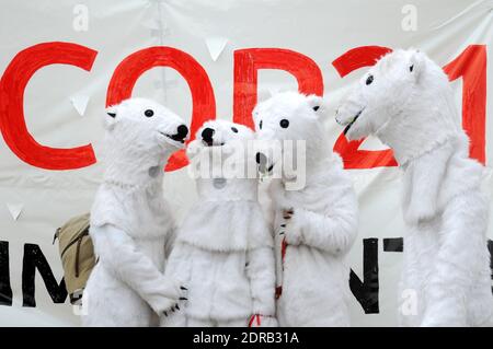 Les personnes portant des costumes d'ours polaires sont vues tandis que les activistes présentent une manifestation près de la Tour Eiffel à Paris, en France, le 12 décembre 2015. Un projet d'accord de 195 pays visant à réduire les émissions de gaz piégés par la chaleur qui menacent de faire des ravages sur le système climatique de la Terre doit être présenté à la Conférence des Nations Unies sur les changements climatiques COP21 à le Bourget, à la périphérie de Paris. Photo d'Alain Apaydin/ABACAPRESS.COM Banque D'Images