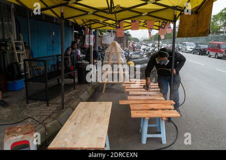 (201221) -- KUALA LUMPUR, 21 décembre 2020 (Xinhua) -- Mohamad Hafiz Johari travaille à l'atelier de Kawood sur la banlieue de Kuala Lumpur, Malaisie, 18 décembre 2020. Mohamad Hafiz Johari, avec deux autres anciens photographes Abdul Razak Abdul Latif et Noor Adzrene Mohd Noor, se sont réunis pour mettre en place Kawood, une combinaison du mot malais kawan (ami) et du bois, Les trois ont perdu leur source de revenu en raison des perturbations causées par la pandémie COVID-19. Ils ont réfléchi à certains moyens de vivre, décidant finalement de mettre leur enthousiasme pour la construction en bui Banque D'Images