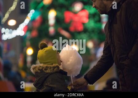 Saint-Pétersbourg, Russie. 20 décembre 2020. Un enfant mange de la soie de bonbons au marché de Noël de Saint-Pétersbourg, Russie, le 20 décembre 2020. Le marché de Noël a ouvert ses portes le 19 décembre et durera jusqu'au 10 janvier de l'année prochaine. Crédit: Irina Motina/Xinhua/Alamy Live News Banque D'Images