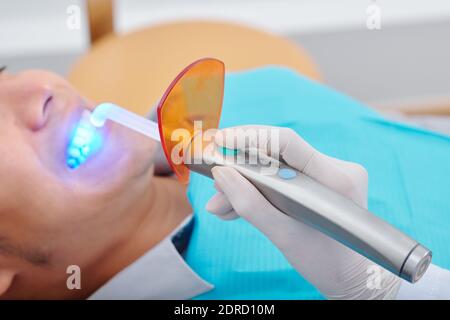 Dentiste utilisant la lumière de durcissement moderne Banque D'Images