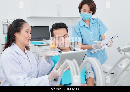 Dentiste et patient discutant de la radiographie de la mâchoire Banque D'Images