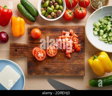 Recette étape par étape pour la salade horiatiki, planche en bois pour couper les légumes Banque D'Images