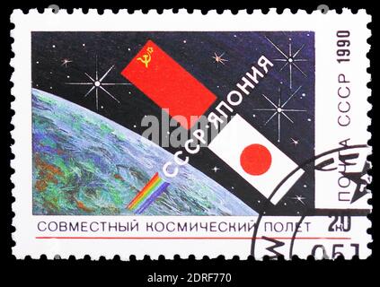 MOSCOU, RUSSIE - 4 JANVIER 2019 : un timbre imprimé en URSS (Russie) montre la Terre et deux drapeaux, vol spatial soviétique-japonais, série, vers 1990 Banque D'Images