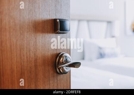 Une photo d'une porte en bois ouverte menant à un chambre minimaliste Banque D'Images